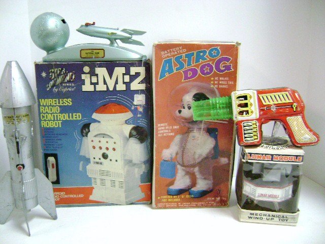 Group of Space Toys: Astro Dog B.O. in O.B. 11"H, I-M-Z robot in O.B., Yone Japan tin wind-up lunar module in O.B., Haji Japan tin space gun with medium wear, Strato Bank 8" L, rocket bank 11" H fair with missing rubber t