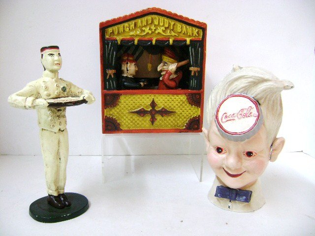 Cast Iron Coca Cola Bank And Others: Cast iron boy's head Coke bank 8" H, Coke iron doorstop 8.5" H, and reproduction cast iron Punch and Judy mechanical bank
