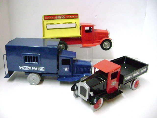 Three Metalcraft Style Trucks: Contemporary police patrol patty wagon 12" L, sand gravel and stone truck 10.5" L, and Coke truck 11" L without bottles