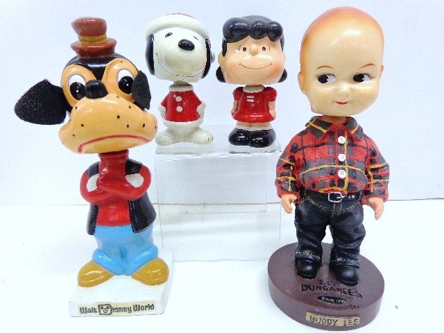 Peanuts and Novelty Bobble Head Dolls: Four bobbles to include: Peanuts Lucy and Snoopy in Santa Suit 4 inches tall, marked Japan, Walt Disney World " Goofy" bobble head 8" tall and Buddy Lee bobble head from Lee Dungarees 8" tall
