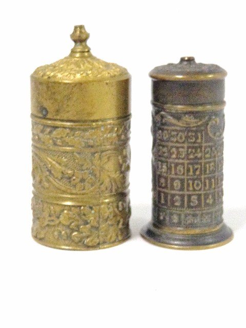 Pair Early Round Vesta Cases with Calendar: Pair of nice early cylinder patent brass match cases, case embossed w/calendar on side, day of week, wheel on bottom spins, 2.25 in. (h), 2nd case has floral repousse on sides 2.7 in. (h)