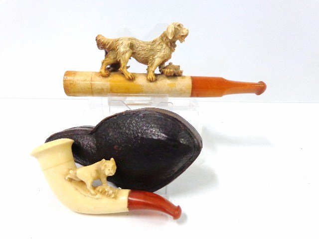 Pair Dog Meerschaum Pipes: Finely carved Meerschaum pipe of hunting dog standing over hare 5.25 in. (l) & small pipe in case w/dog w/leg up in the air 3 in. (l)