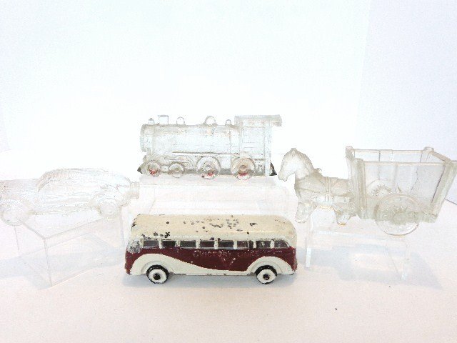 Four Glass Transportation Candy Containers: Group of 4 transportation related glass candy containers, locomotive w/closure 5 in. (l), auto sedan 4 in. (l), horse cart 4.75 in. (l) & Victory Bus Lines streamlined bus 5 in. (l), repainted w/chip 