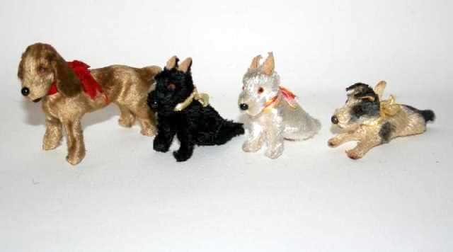 Pooches from the Past: Vintage plush pets: four small dogs, one with paper label "Made in Germany", tallest 2.25" H, all with original bows and showing they have been loved.