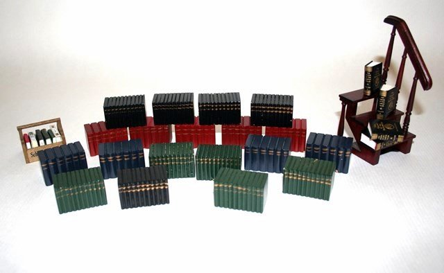 Barbara Raheb in the Library: A collection of 24 carved wooden book sets approx 7/8" H (prob Chestnut Hill), a German book carrier, four copies of the Hound of the Baskervilles printed by Janet Raheb and additional faux books. Als