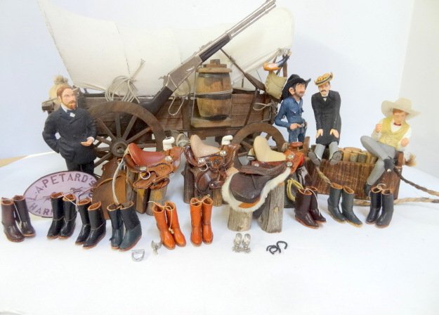 Covered Wagon with Western Accessories: Fabulous miniature covered wagon with three Cecil Boyd cowboy figures 5" H, eight pairs leather boots, three leather saddles, rifle, spurs, etc. Has it all. Wagon 10" H, 15" L, 6" W.