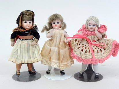 All Bisque Dollhouse Dolls: Three all bisque Dollhouse Dolls, all with glass eyes, vintage clothing, original wigs, molded shoes, 4 in.