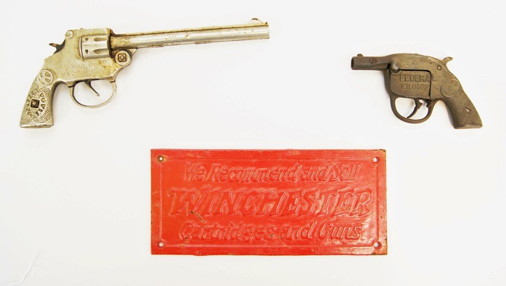 Winchester Cast Iron Sign & Cap Pistols: Early Winchester cast iron sign with original red paint 9.25" x 4.25", Kilgore #1 cast iron cap pistol, Kilgore Safety Trooper cap gun, plated cast iron 10" L