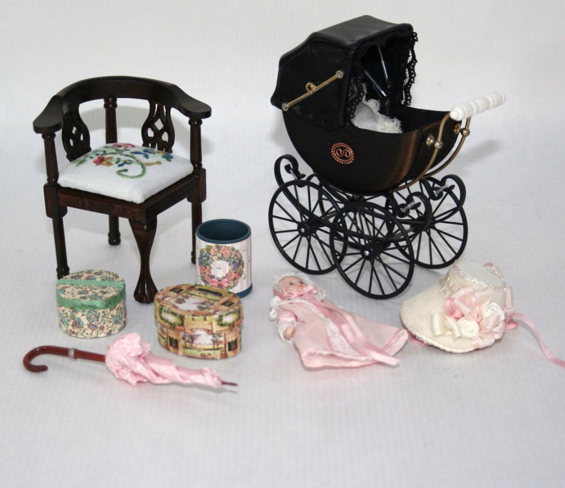 Baby and Bonnet: A Heidi Ott baby carriage with a bisque infant girl, a Fantastic Merchandise corner chair with embroidered seat cushion, hatboxes, bonnet, parasol and wastebasket.