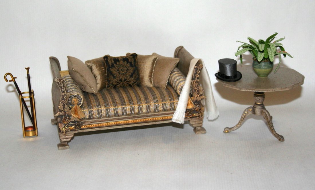 Embellished Daybed: For an elegant gentleman, an unsigned painted and antiqued daybed that has been embellished with molded details and upholstered in a masculine way, pillows glued in place, 3" H, 6.25" L, with an impor