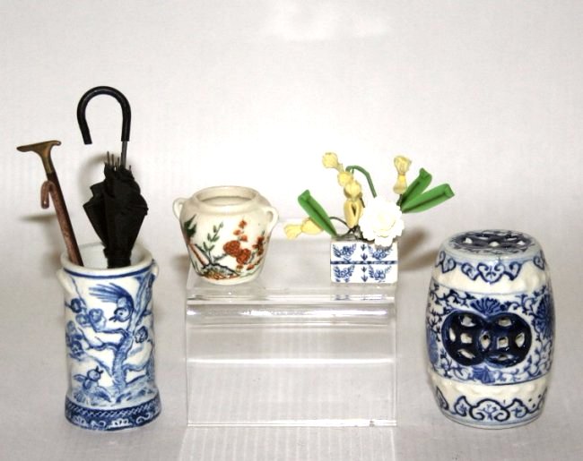 Jean Tag Fine Porcelain: A blue and white umbrella stand 1 and 5/8" H with two umbrellas and a walking stick, a Delft flower brick, a Chinese vase, all signed by Jean Tag, and an unsigned garden seat attributed to the artist.
