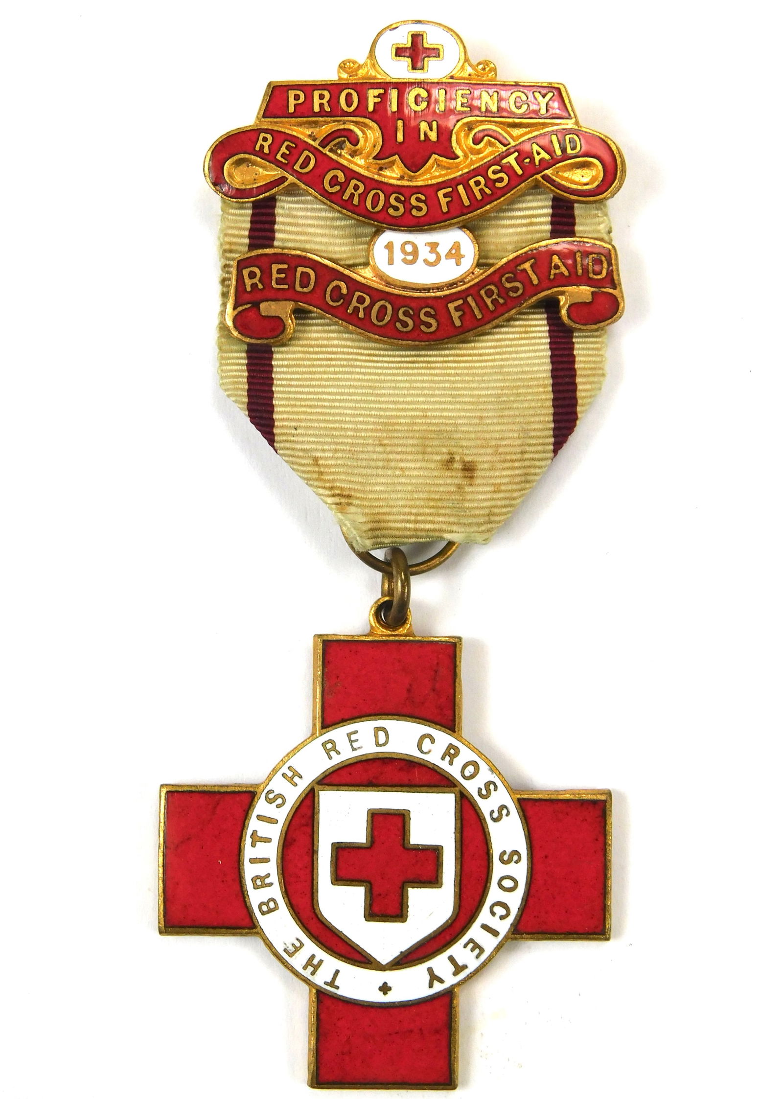 British Red Cross Society Proficiency in First Aid Medal with 1934 Bar Named: In-House Shipping. British Red Cross Society Proficiency in First Aid Medal with enamel cross and 1934 date bar. Original ribbon and pinback. Reverse engraved 09961 E.A. Curtis. Nice early example wit