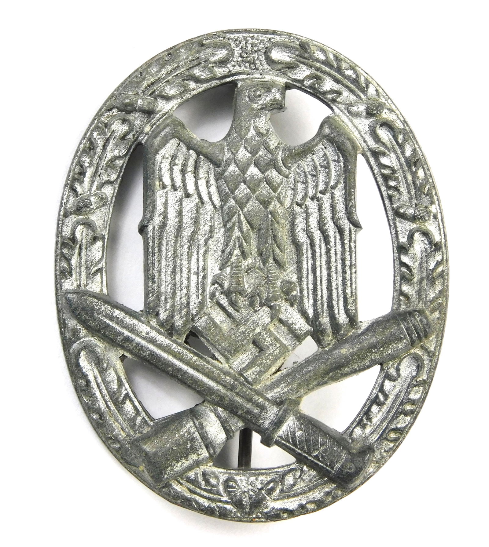 German WW2 General Assault Badge GAB Infantry Assault Variant Zinc Badge: In-House Shipping. German WW2 General Assault Badge zinc construction, oval wreath with eagle holding swastika over crossed bayonet and stick grenade. Reverse with functional pin and hinge, solid-back