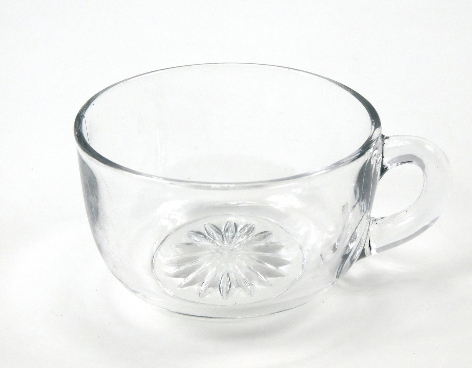 Vintage Heisey Clear Glass Punch Cup Teacup Diamond H Mark Starburst: In House Shipping. Vintage clear glass punch cup or teacup by A.H. Heisey & Company. Features smooth clear glass sides, a loop handle and pressed starburst design on the underside. The base bears the 