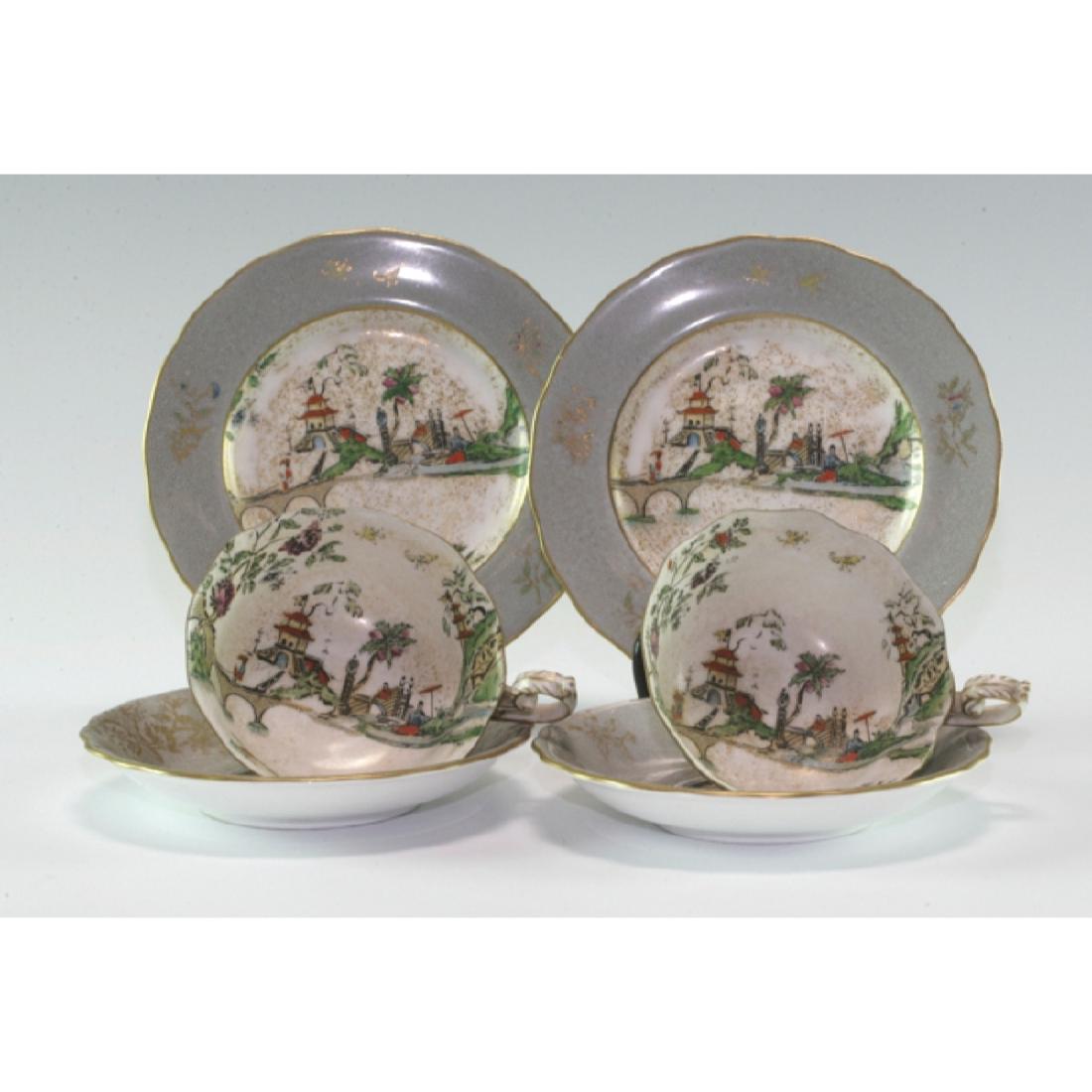 Pair Of Vintage Royal Worcester Tea Cup Sets: Painted with a China-ware subject. Each set is three pieces - Cup, Saucer and Plate. Puce mark on the base. Late 19th century.