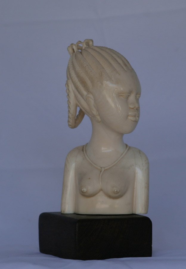 Solid African ivory bust of a native girl: Early 20th century. On a wooden stand.