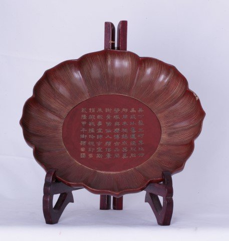 A Cinnabar Water Lilly Shaped Flat Bowl.: Very attractive piece 9a small chip to the rim). Features a poem in the centre. 22cm wide.