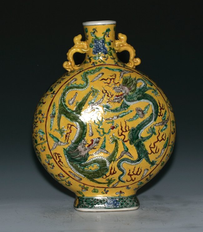 Moon Flask Vase: Imperial yellow glaze, presented with two green dragons on the face. Two temple dog handles on the short neck. 39.5cm height.