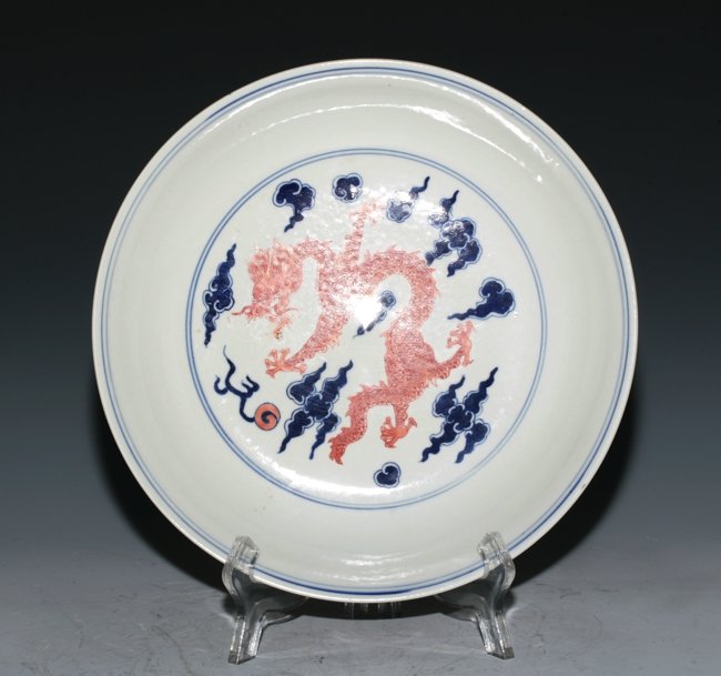 Large Famille Rose Dish: Presented with a red dragon flying in the sky. The back side decorated with two red dragons alongside blue clouds. Six Kang Xi mark on the base. 25cm diameter.