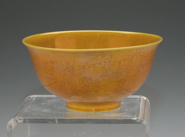Chinese Imperial Yellow Bowl: Emplaced with a phoenix flying across the clouds. 15cm diameter. Ming dynasty mark on the base