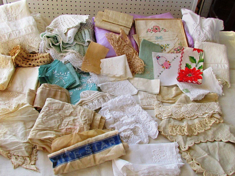 Large Lot of Notions with Bedspread Set.: Lot of antique linens, embroidered satin bedroom set including bedspread, various sized pillows, runner, etc. large linen table cloth, lunch set, doilies, runners, handkerchiefs, lace collars, trim, a