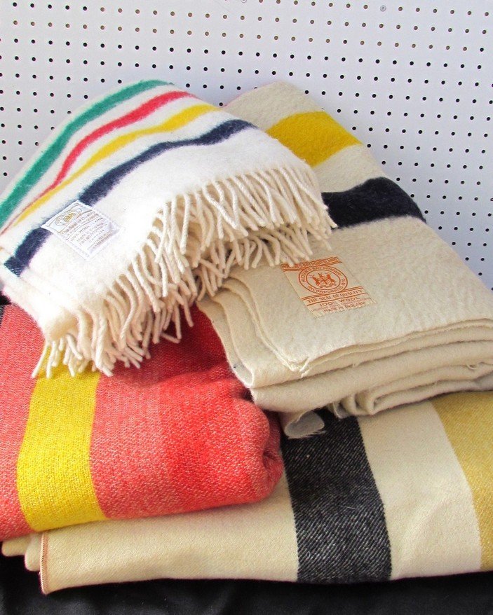 Hudson Bay Blanket and Teddy Bear Lot.: Three Hudson Bay wool point blankets, throw, and a collection of collectible Hudson Bay teddy bears.