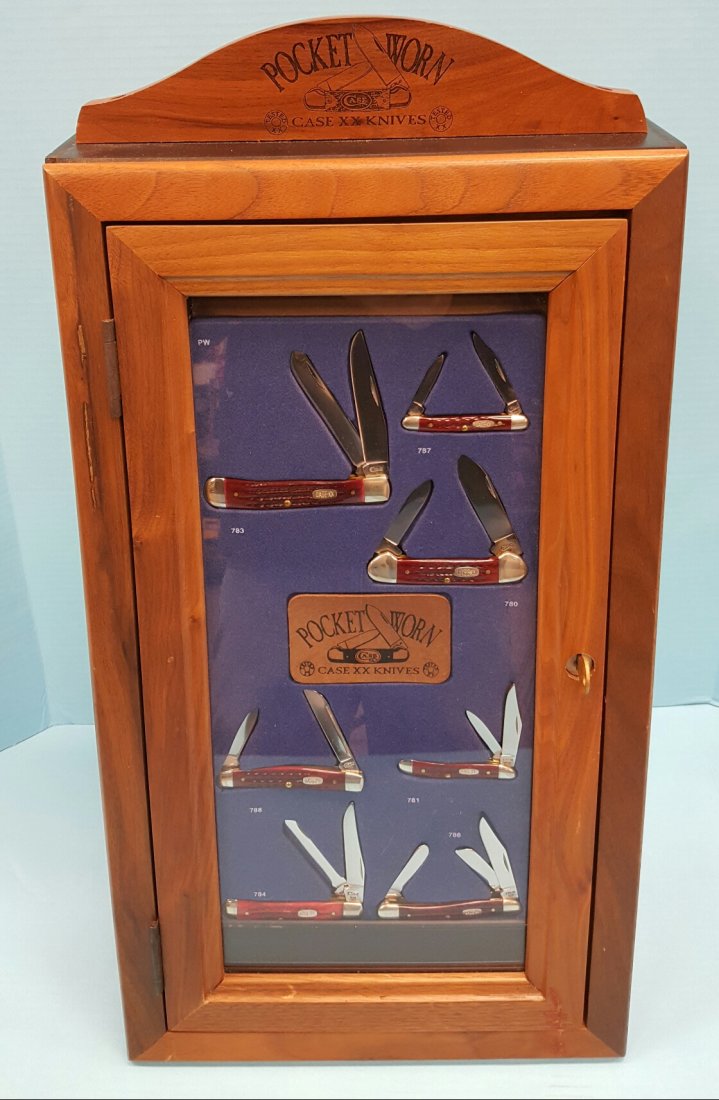 7 Pocket Worn XX Case Knives & Wood Display Case: 7 Case Pocket Worn knives with boxes and wood display case. The display case has a slant front with plexiglass window to show the knives and wood trim. there is a handsome solid wood topper with the C