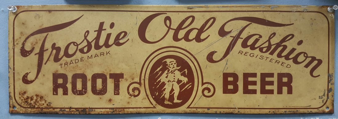 Frostie Old Fashion Root Beer: 19.5 x 6.5 tin sign made by Parker Metal. The sign has scuffs, scratches, paint flaking and minor rust.