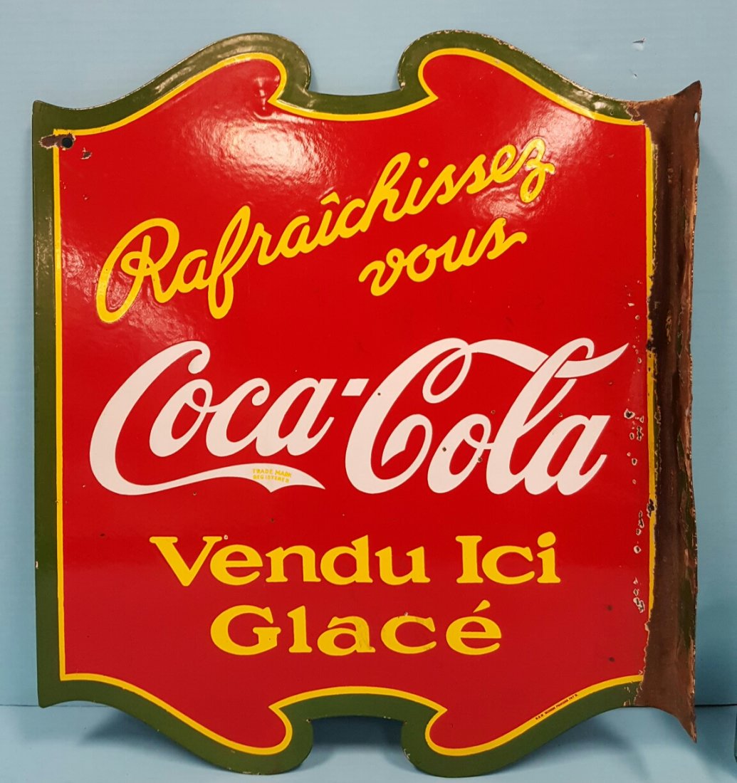 Porcelain Coca Cola Flange Sign Canadian: 17" x 20"h red, green, yellow, & white circa 1930's two sided flange sign with minor porcelain chips on both sides. The sign looks like it was straightened and rebent at one point so most of the porce