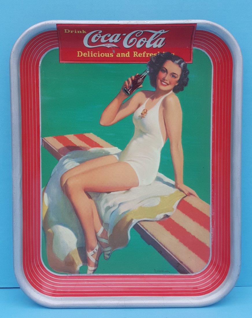 1939 Coca Cola Tray: An original tray with girl in white swimming suit. The tray is in very presentable condition with a few minor paint flakes. The tray appears to have been sprayed with a clear coat at some point which 