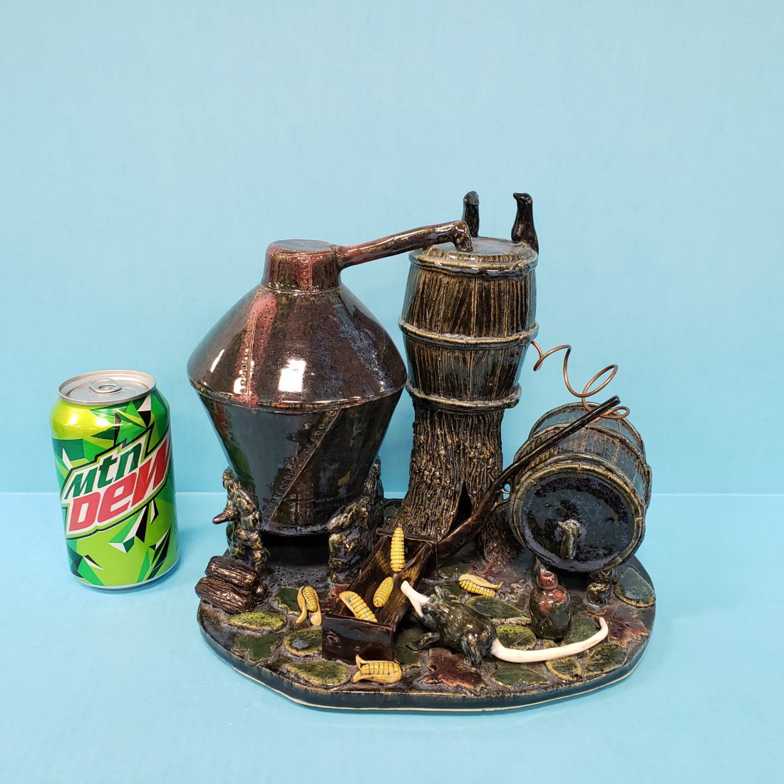 Lin Craven Moonshine Scene Southern Folk Pottery: 9.5" 2002 Intricately detailed moonshine still including complete still with copper, birds, shotgun, whiskey jug, possum, trough, corn on the cobs, wood logs, tree stump, snake, and multi colored foli