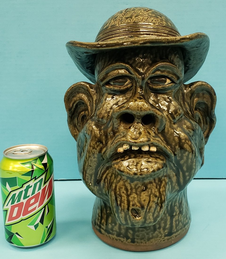 Cleater Meaders Jr. Charlie Daniels Face Jug. 1892-1992: 12" Glazed Charlie Daniels face jug with Mossy Creek Monsters on the hat and "Charlie Daniels Meaders Pottery 1882-1982 100 years on the back. Signed and dated on the bottom. PLEASE READ & UNDERSTAND 