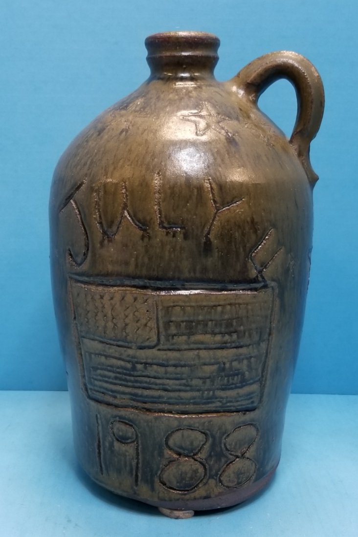 Chester Hewell July 4th Jug: 12" Glazed jug with July 4th, American Flag, and 1988 on the front. Your a high flying flag Gillsville Ga. on the back. Excellent condition. Signed and dated 1988 on the bottom. PLEASE READ & UNDERSTA