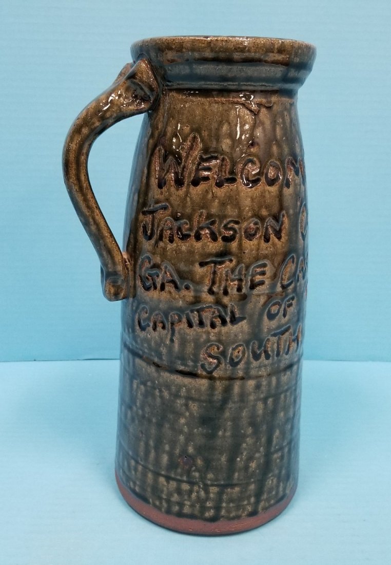 Clete Meaders Folk Art Milk Pitcher: 11.25" Glazed pitcher with Milk incised on one side and "Welcome to Jackson County GA. The car-choping capital of the South. Signed and dated on the bottom 2008. Excellent condition. PLEASE READ AND U