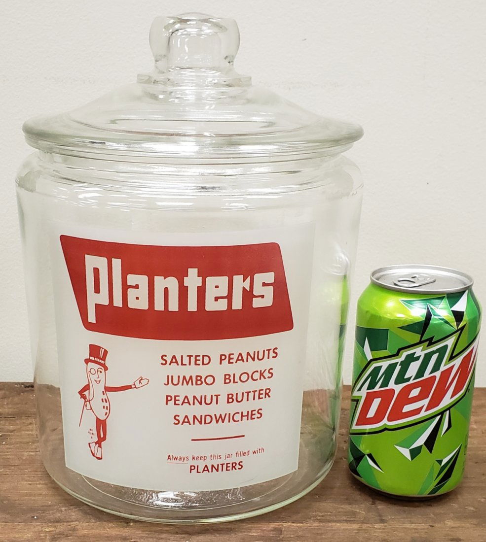 10" Planters Peanuts Jar with glass lid: Glass jar and lid in excellent condition with Planters logo on the front. PLEASE READ AND UNDERSTAND THE PAYMENT AND SHIPPING TERMS FOR THIS AUCTION PRIOR TO PLACING BIDS. ALL BIDDERS ARE BOUND TO THE