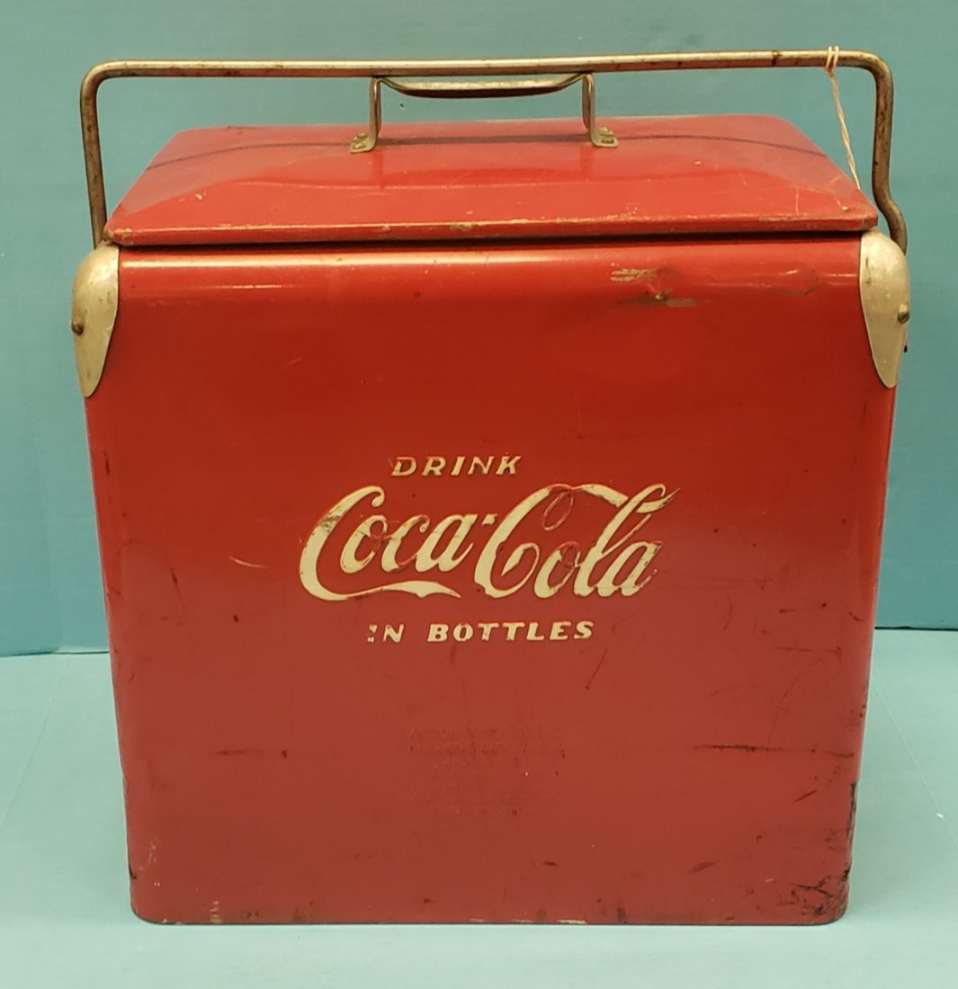 Coca Cola Embossed Picnic Cooler: 19" x 12" x 19"h Coca Cola cooler embossed on two sides with aluminum tray. Cooler shows normal wear including scuffs & scratches. PLEASE READ & UNDERSTAND THE PAYMENT & SHIPPING TERMS FOR THIS AUCTIO