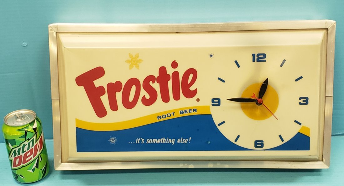 Frostie Root Beer Light Up Dualite Electric Clock: 19" x 10" Clock with plastic face and aluminum housing. Bright colors and minor scuffs. PLEASE READ & UNDERSTAND THE PAYMENT & SHIPPING TERMS FOR THIS AUCTION PRIOR TO PLACING BIDS. ALL BIDDERS ARE BO