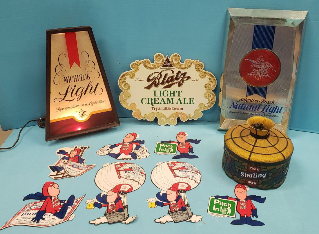 Beer Advertising Lot: Beer lot including a 1976 NOS Cardboard Blatz window sign, 8"dia. plastic Sterling hanging light shade, 10" x 18" Natural Light plastic sign, and 7 Bud Man Stickers. PLEASE READ & UNDERSTAND THE PAYME