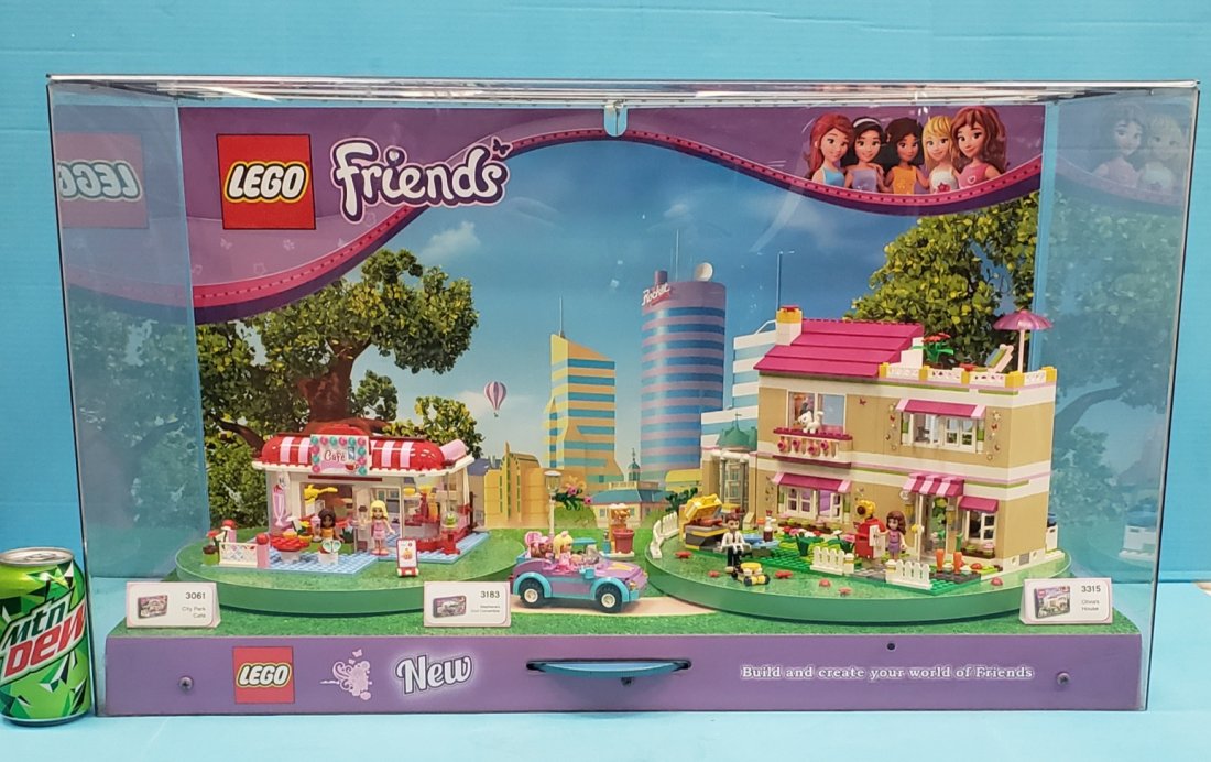 Lego Friends Store Display: 31.25"w x 16.25"d x 18.5" Plexiglass store display with Lego City Park Cafe, Stephanie's Cool Convertible, and Olivia's House assembled inside the display. There is a wheel in front to rotate the cafe