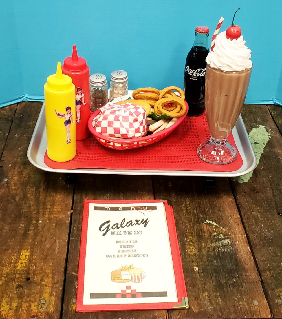 Drive-in carhop window food tray car show prop: Fun drive-in window food tray with Galaxy Drive In menu, burger, onion rings, milkshake, salt, pepper, Coca Cola, and pin-up girl mustard and ketchup. These are great props for car shows. PLEASE NOTE,
