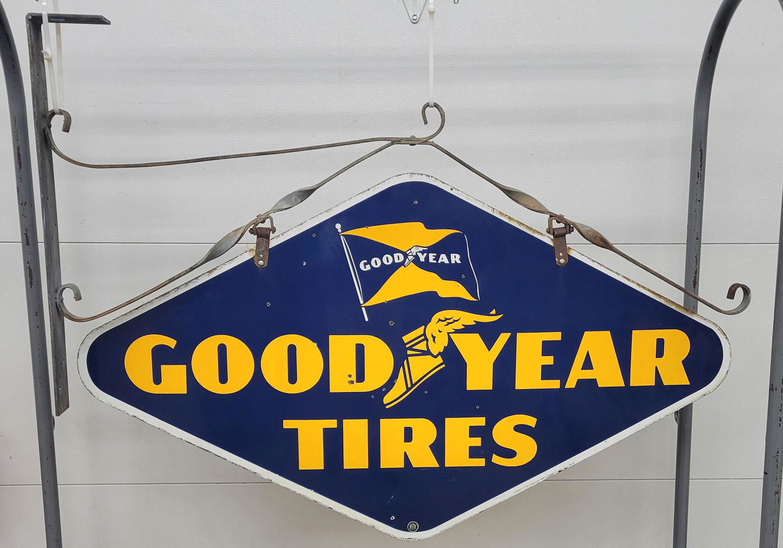 Goodyear Tires Porcelain Sign With Hanging Bracket TAC: Double sided porcelain sign with bright colors, high gloss, minor porcelain chips and light edge wear. The iron hanging bracket is in excellent condition unpainted. 57" x 41" with bracket. TAC #002906