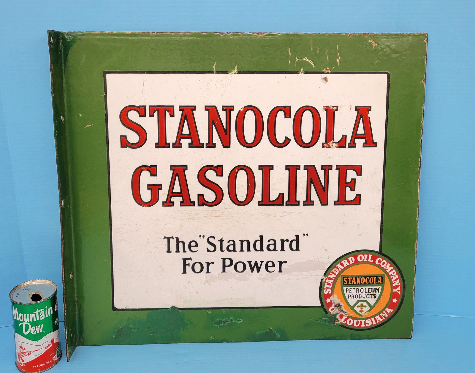 Stanocola Gasoline Porcelain Flange Sign: Porcelain flange with touch ups, porcelain chips, scuffs, scratches, and stains. 22" x 20". PLEASE NOTE, THERE IS ONLY ONE WAY TO PAY FOR ONLINE ITEMS IN THIS AUCTION WHICH IS THROUGH LIVE AUCTIONEERS