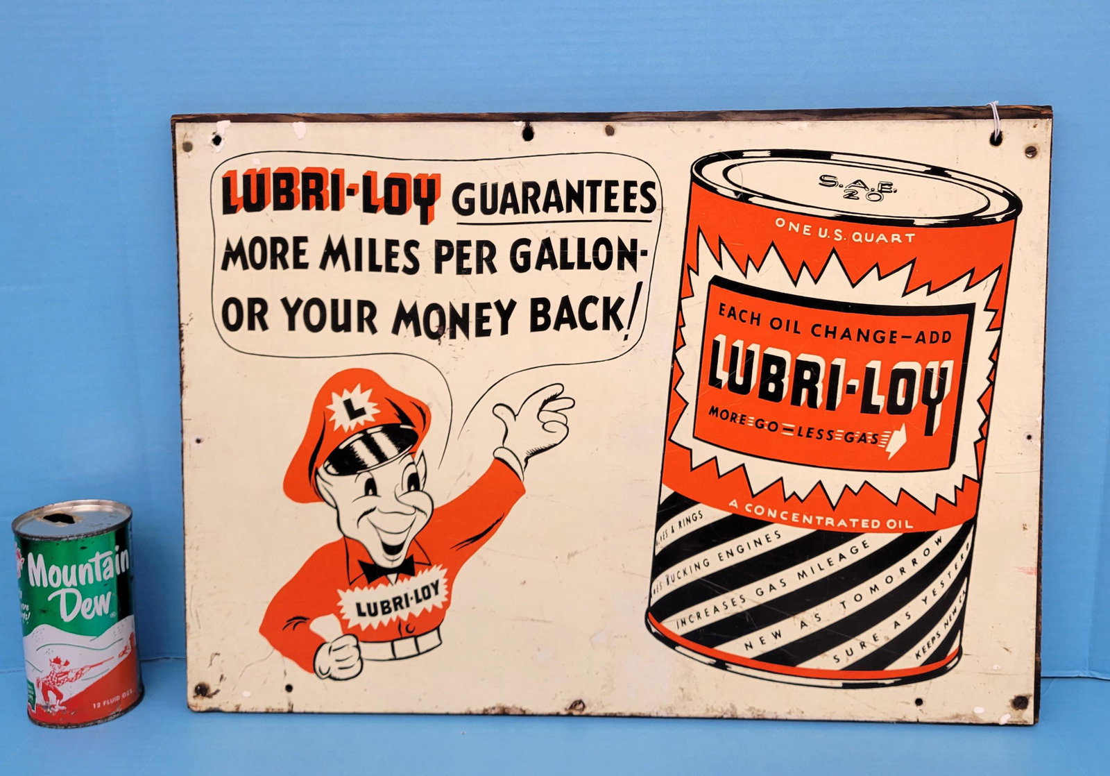Lubri-Loy Guarantees Metal on wood sign: Metal sign mounted on wood. Shows bright colors with light stains, scuffs and scratches in the field. 20.5" x 14.5". PLEASE NOTE, THERE IS ONLY ONE WAY TO PAY FOR ONLINE ITEMS IN THIS AUCTION WHICH IS