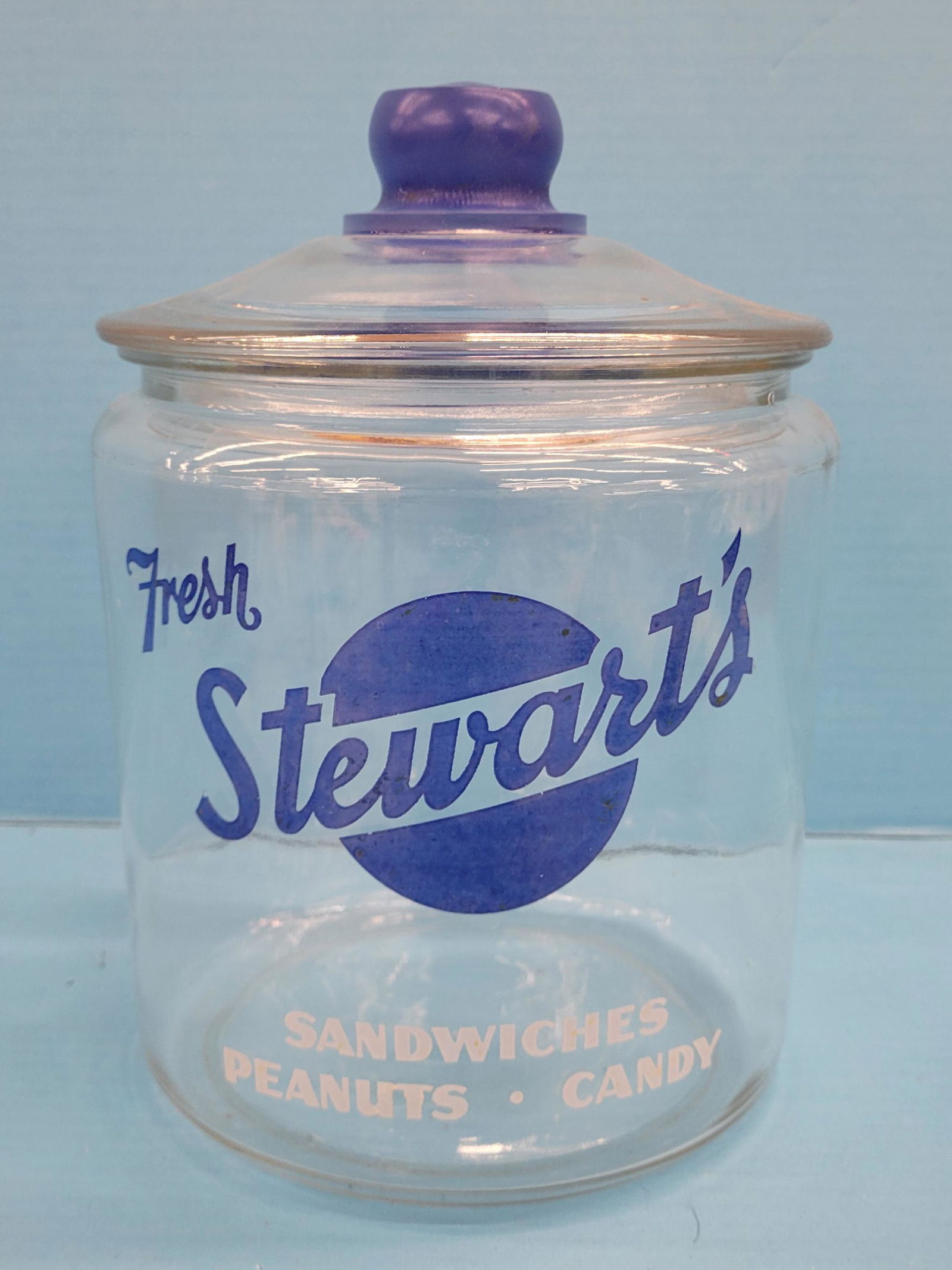 Fresh Stewart's Sandwiches, Nuts, Candy Jar with Glass Lid: 10" Glass jar with logo on front. The jar inner rim has a few very small nicks. PLEASE NOTE, THERE IS ONLY ONE WAY TO PAY FOR ONLINE ITEMS IN THIS AUCTION WHICH IS THROUGH LIVE AUCTIONEERS. THIS IS TH