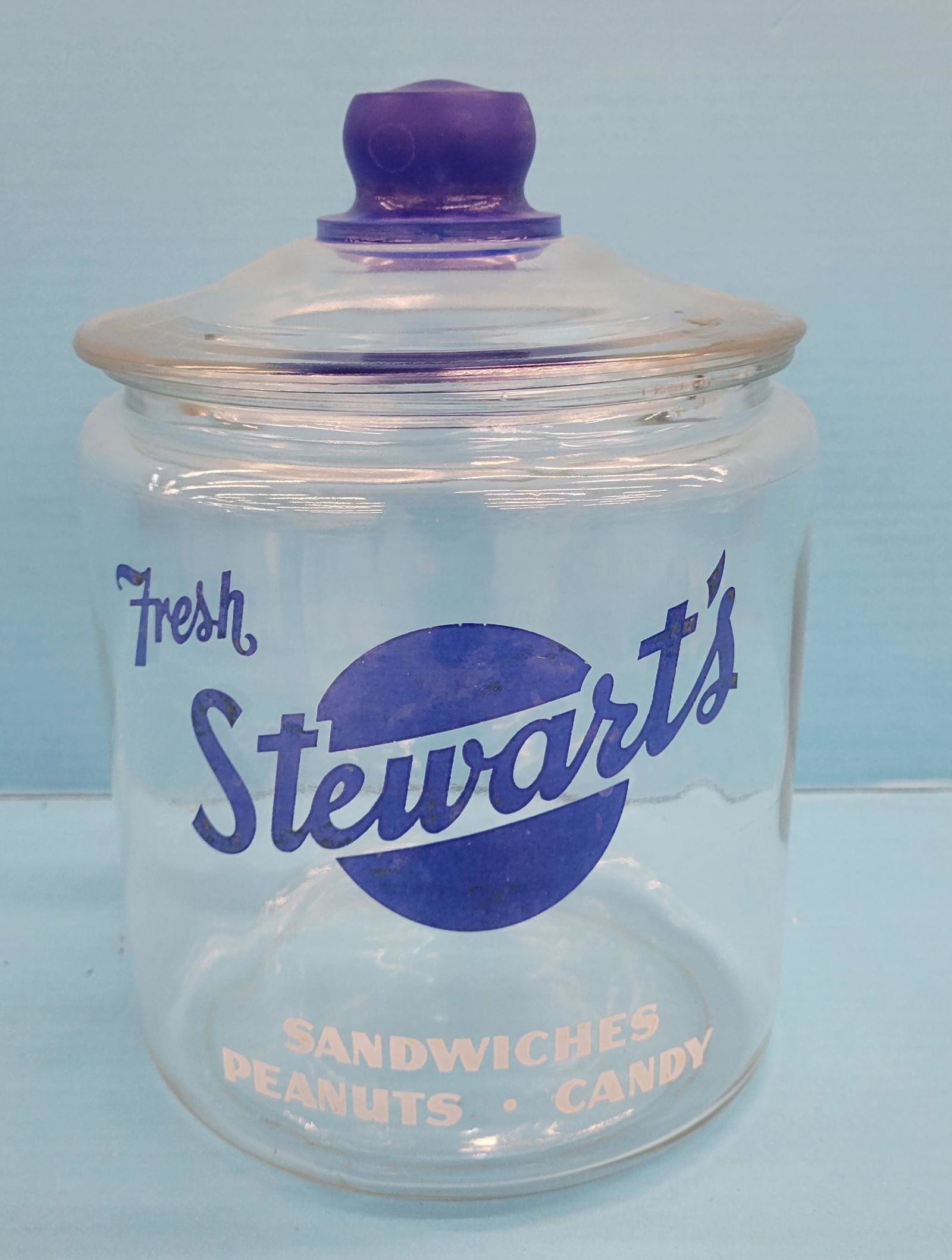 Fresh Stewart's Sandwiches, Nuts, Candy Jar with Glass Lid: 10" Glass jar with logo on front. The lid has a small chip and the jar inner rim has a few small nicks. PLEASE NOTE, THERE IS ONLY ONE WAY TO PAY FOR ONLINE ITEMS IN THIS AUCTION WHICH IS THROUGH LIVE