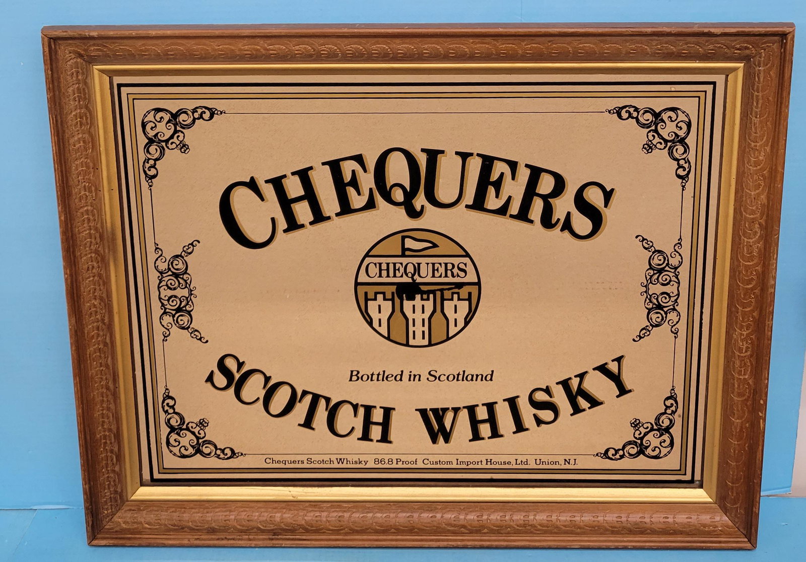 Chequers Scotch Whisky Framed Mirror: 27.25" x 21.25" Wood framed Chequers Bottled in Scotland advertising mirror in good condition with normal wear. PLEASE NOTE, THERE IS ONLY ONE WAY TO PAY FOR ONLINE ITEMS IN THIS AUCTION WHICH IS THRO