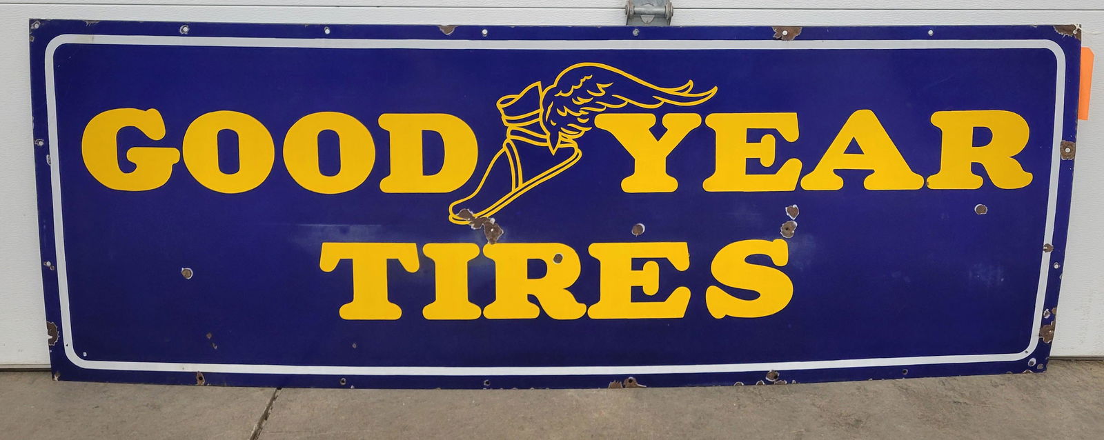 Goodyear Tires Single Sided Porcelain Sign With Winged Foot: 66" x 24" SSP sign with good color, porcelain chips in the field, around the edges, and mounting holes. There are light scuffs in the field. Sign is marked on back Property of Goodyear Tire and Rubber