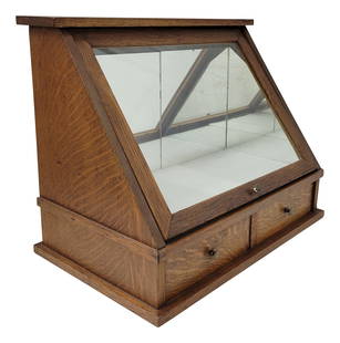 Antique Tiger Wood Oak Country Store Slanted Front Showcase: Small 2 drawer countertop showcase with tiger wood cabinet and glass flip up front. The glass front will slide down into the cabinet for storage while restocking the display. The back interior wall an