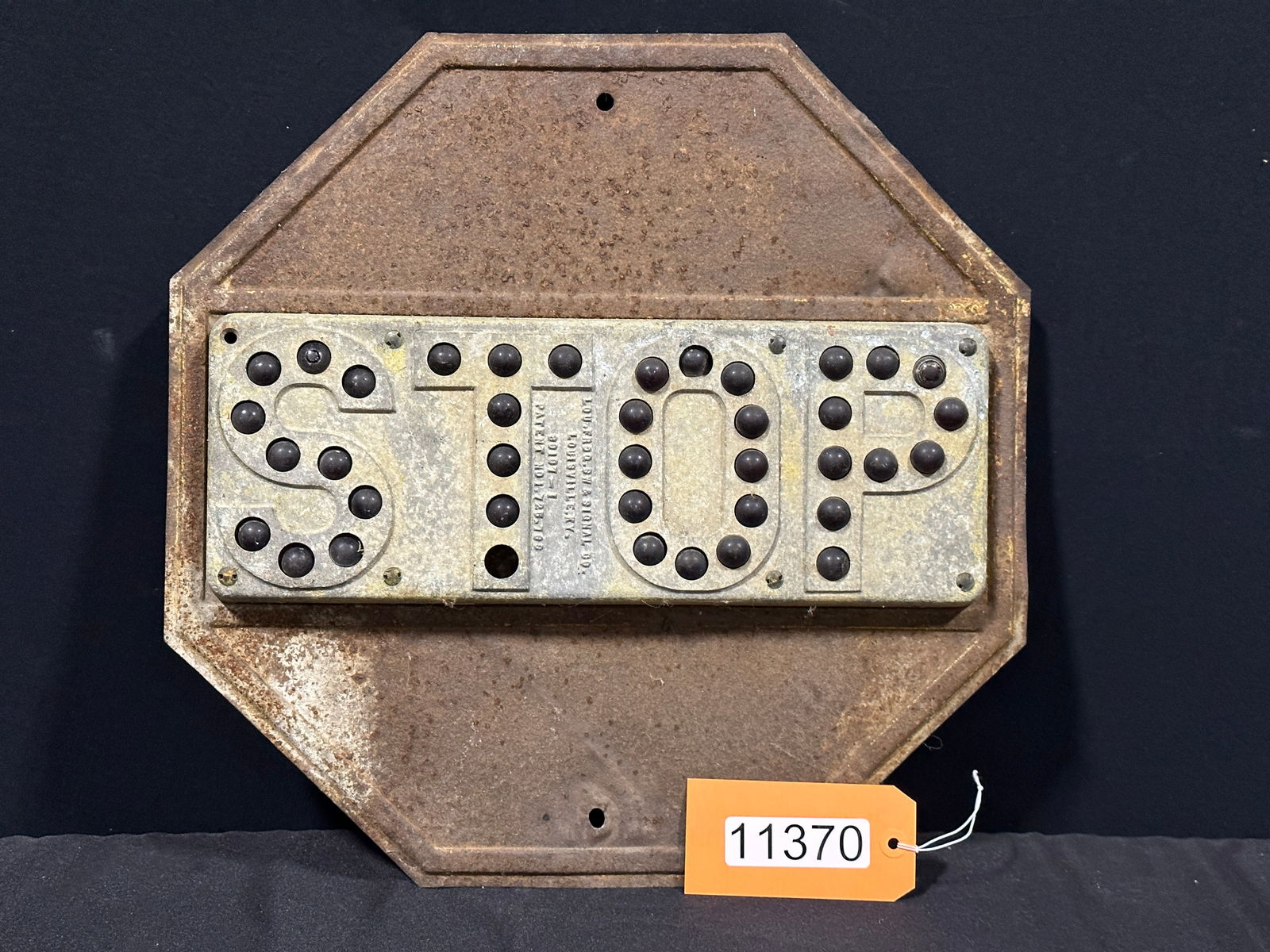 Slightly rusted tin metal cat eye stop sign (1 of 2)