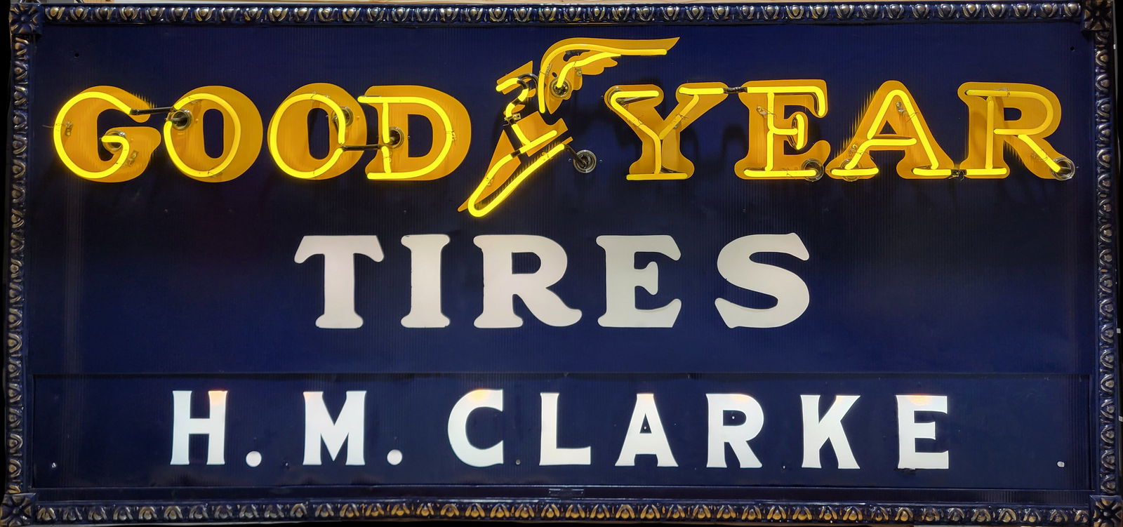 Goodyear Tires H.M. Clarke Double Sided Flexlume Neon Sign: 104" x 23 x 55" (crate) Working double sided neon sign with Goodyear winged boot logo and light up milk glass panel letters. The rippled tin signs and H.M. Clarke privilege panels have been restored o